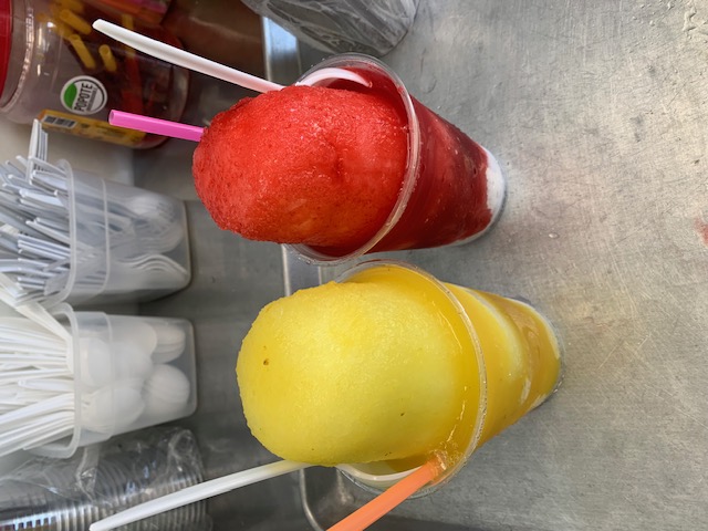 Two shaved ice cups in bright flavors